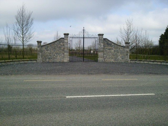Curved stone walls and modern metal gates at the entrance to a house in Co Meath