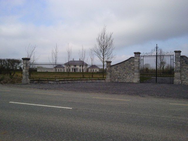 Modern gates set in stone walls beside a regional road in Co Meath